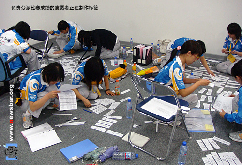 北京奥运MPC里,为记者服务的人们——负责分发比赛成绩的志愿者正在准备标签。