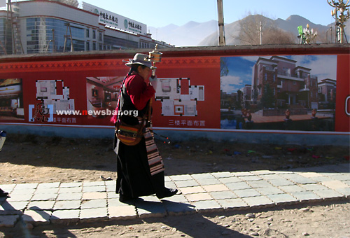 西藏：转经的妇人走过一个在建中的楼盘……